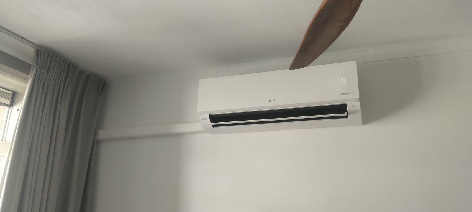 Airco in een bovenwoning: twee binnenunits, één buitenunit LG binnenunit met wit afwerkkanaal langs de wand