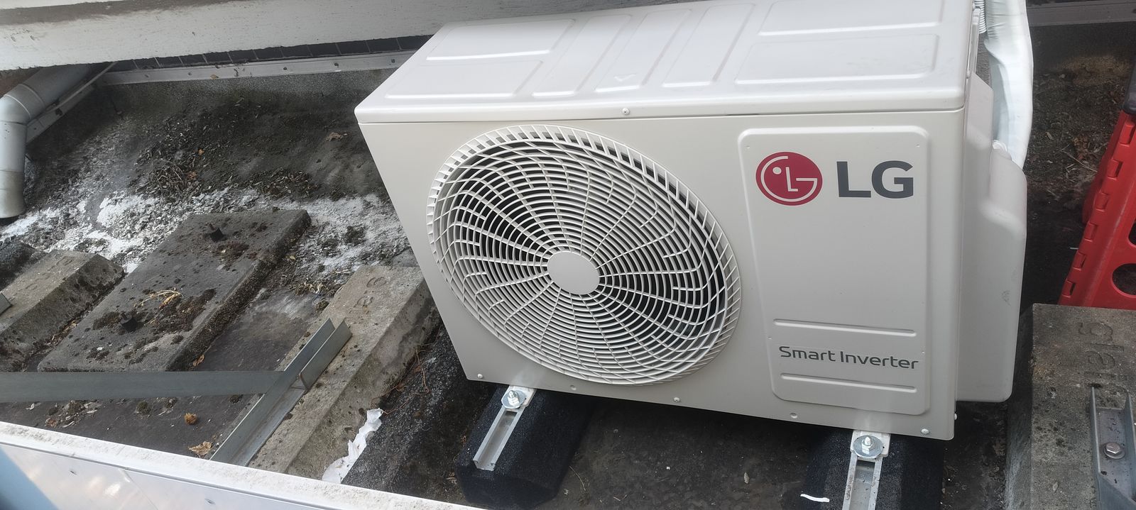 Airco in een bovenwoning: twee binnenunits, één buitenunit LG Smart Inverter buitenunit 5 kW op trillingdempers op een plat dak