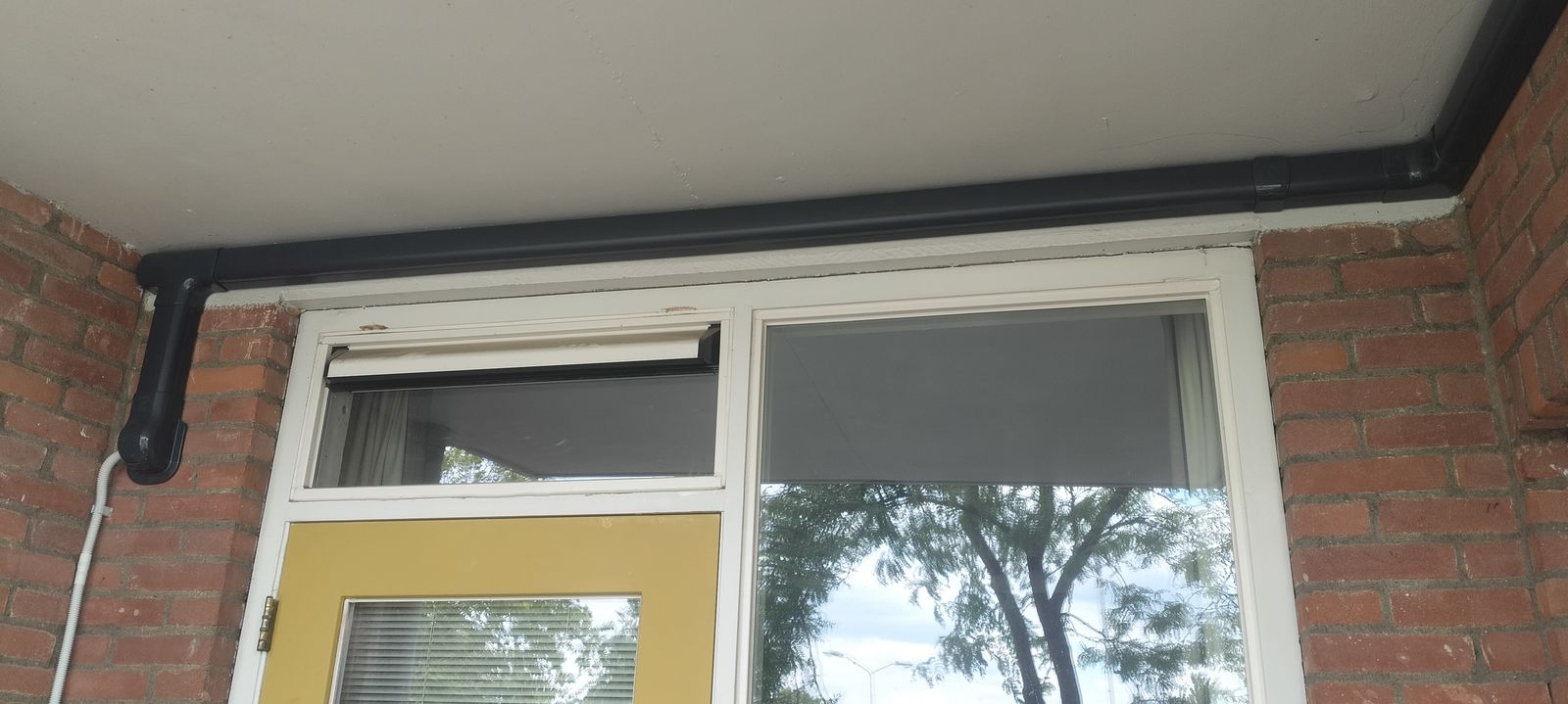 Airco in een bovenwoning: twee binnenunits, één buitenunit Antraciet afwerkkanaal met koelleidingen langs de gevel van een bovenwoning