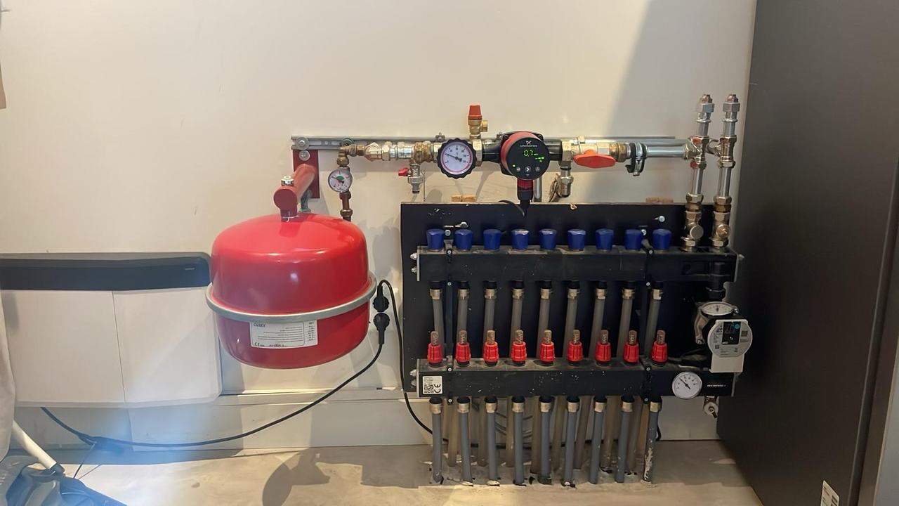 Van pelletkachel naar warmtepomp: Nibe F2050-6 met vloerverwarming Vloerverwarmingsverdeler aangesloten op een monoblock warmtepomp met expansievat en circulatiepomp